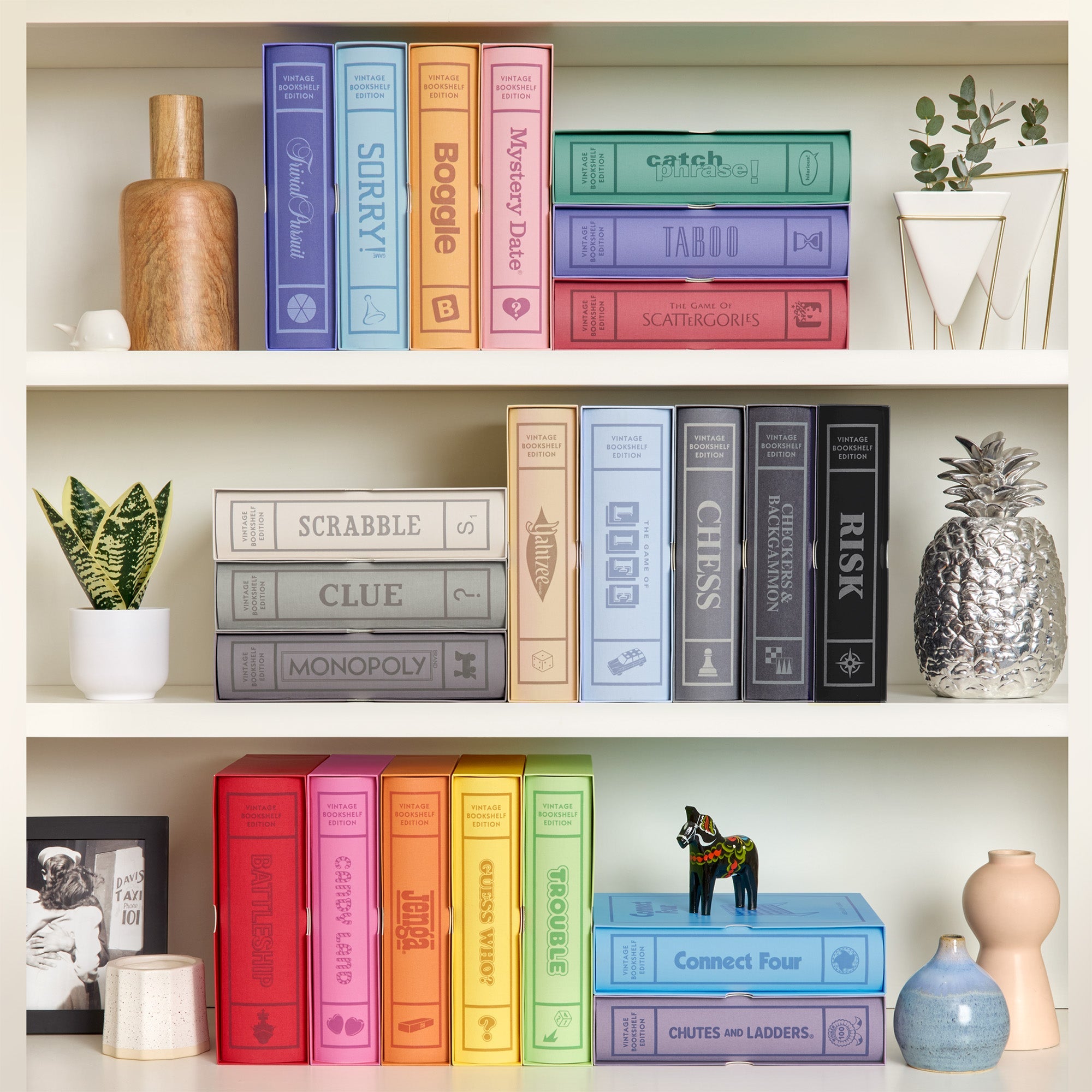 WS Game Company Vintage Bookshelf Games collection featuring linen-wrapped book editions of Monopoly, Scrabble, and Clue displayed on a bookshelf.