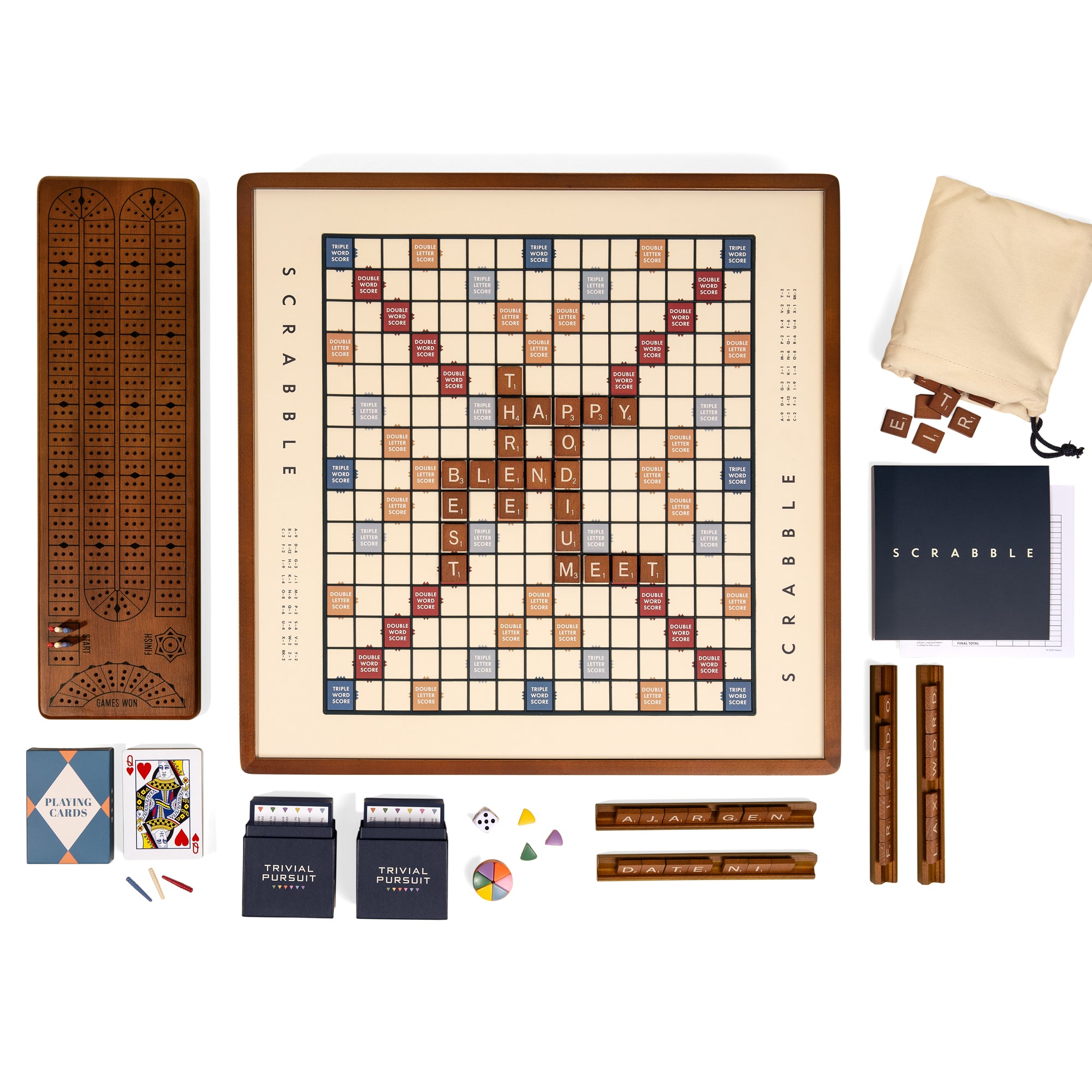 Deluxe Scrabble board game set with wooden tile racks, Trivial Pursuit cards, cribbage board, and playing cards.