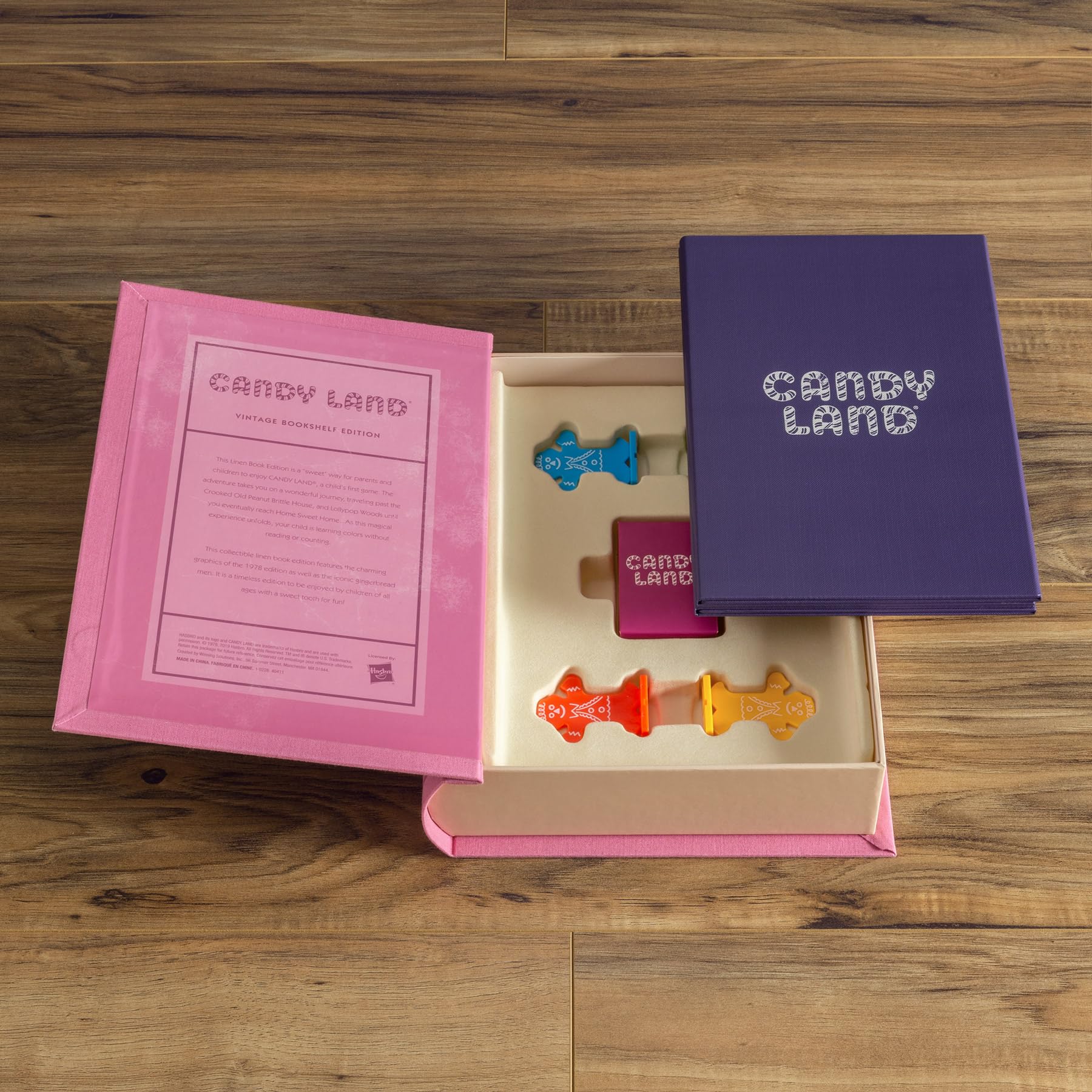 Candy Land game pieces in a pink box on a wooden surface