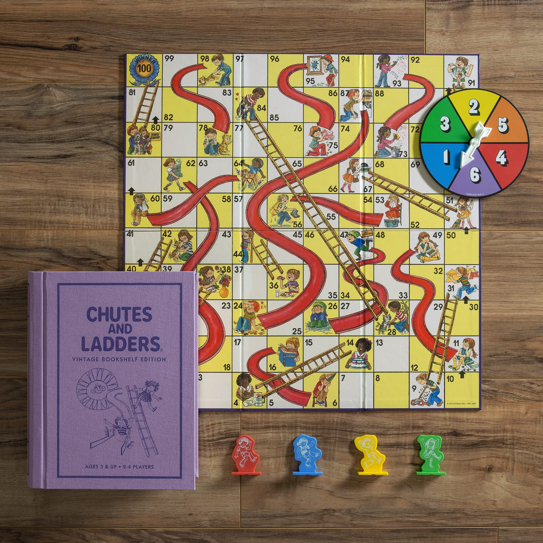 Chutes and Ladders board game with pieces and rulebook on a wooden surface