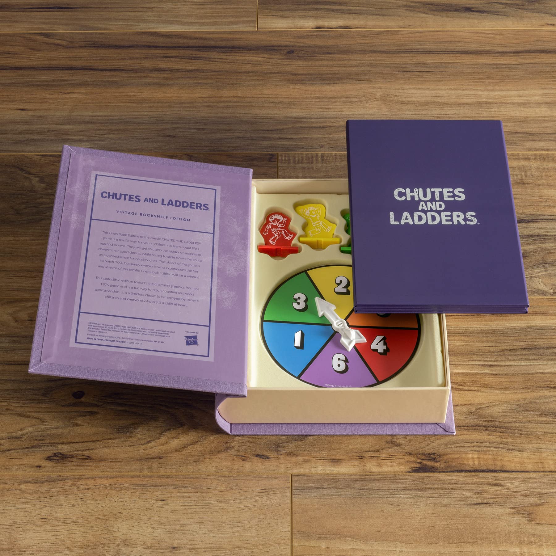 Chutes and Ladders game board in an open box on a wooden surface