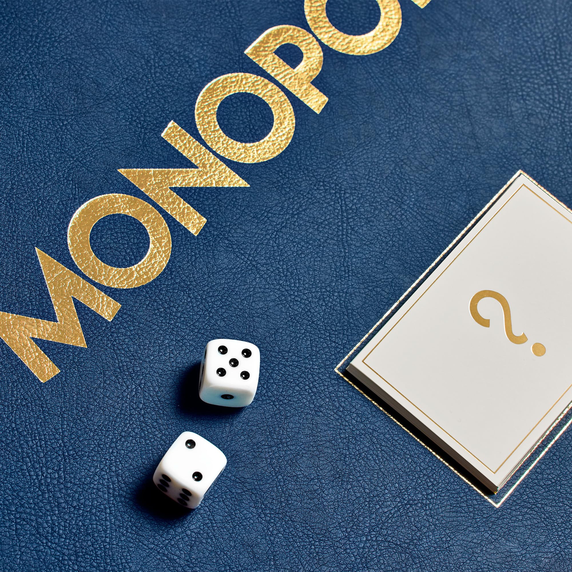 Monopoly game board with dice and question card on a blue surface