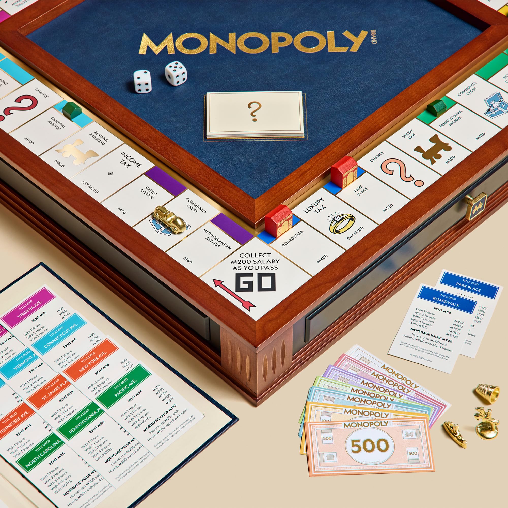 Monopoly board game with pieces, cards, and dice on a beige surface
