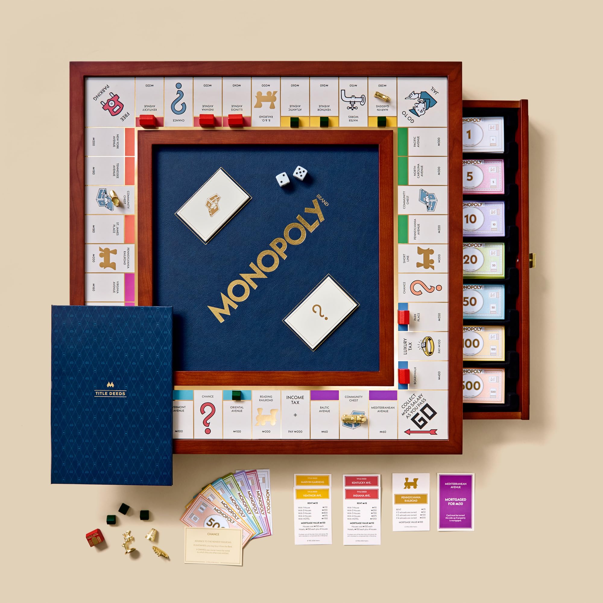 Monopoly board game set with pieces and cards on a beige background